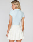 This cream pleated golf skirt pairs nicely with the sky blue Smoothing Zip Top